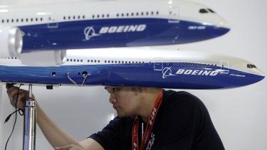 Un trabajador instala los modelos de aviones de pasajeros Boeing en el stand de la compañía para el próximo Salón Aeronáutico de Singapur el domingo 9 de febrero de 2014.&nbsp;