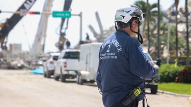 Un rescatista camina por el perímetro del área donde se desplomó un edificio en la municipalidad de Surfside.