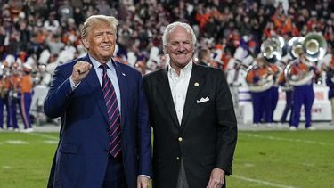 El expresidente y aspirante a la candidatura republicana Donald Trump hace un gesto junto al gobernador de Carolina del Sur, Henry McMaster, en el descanso de un partido del torneo universitario de fútbol americano NCAA entre la Universidad de Carolina del Sur y Clemson, el sábado 25 de noviembre de 2023, en Columbia, Carolina del Sur.&nbsp;