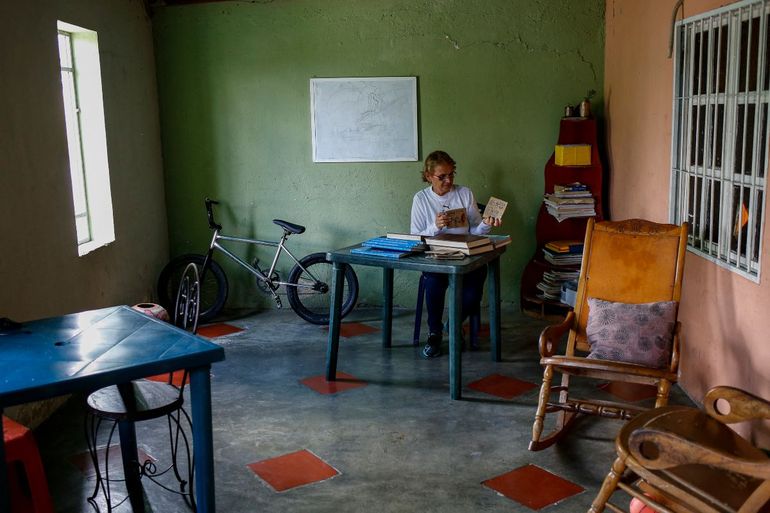 Nuris Marbella Lorenzo, una maestra de 53 años, arregla libros en un aula improvisada en su casa en Montalbán, Estado Carabobo, Venezuela.