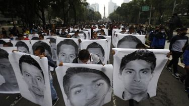 Estudiantes normalistas muestran las fotografías de los 43 estudiantes desaparecidos de la Escuela Normal Rural de Ayotzinapa al acompañar a los familiares en una marcha en el sexto aniversario de la desaparición de los 43 estudiantes, en Ciudad de México, el sábado 26 de septiembre de 2020. ()