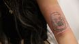 La clienta Kimberly Westgarth sentada en Naama Studios, una clínica de eliminación de tatuajes en Marylebone, Londres, el 14 de diciembre de 2022, muestra su tatuaje que representa al cantante estadounidense Kanye West.