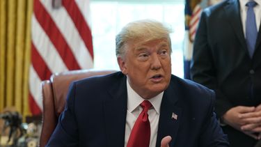 El presidente Donald Trump habla con asesores en la Oficina Oval en la Casa Blanca.