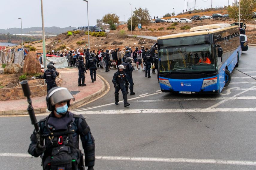 La policía española escolta a migrantes en autobuses tras haberlos reunido mientras dormían a la intemperie cerca de los almacenes de El Tarajal, en las afueras de Ceuta —enclave español en el norte de África—, el 18 de octubre de 2026.