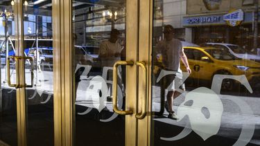 La gente pasa frente a las puertas del Teatro Majestic en la ciudad de Nueva York el 13 de abril de 2023, antes del cierre de El Fantasma de la Ópera el 16 de abril, después de funcionar durante 35 años en Broadway. &nbsp;