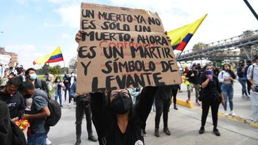 Una mujer sostiene un cartel que dice Un muerto ya no es solo un muerto, ahora es un mártir y un símbolo de levantamiento durante una manifestación contra la reforma tributaria propuesta por el presidente colombiano Iván Duque, en Bogotá, Colombia, en abril. 28 de 2021