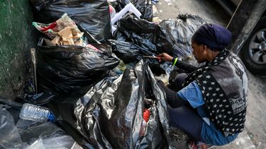 Una mujer hurga en una basura en busca de comida en una calle de Caracas (Venezuela), una imagen que se repite cada vez más y que resume una cosa: el hambre que padecen los sectores más vulnerables.