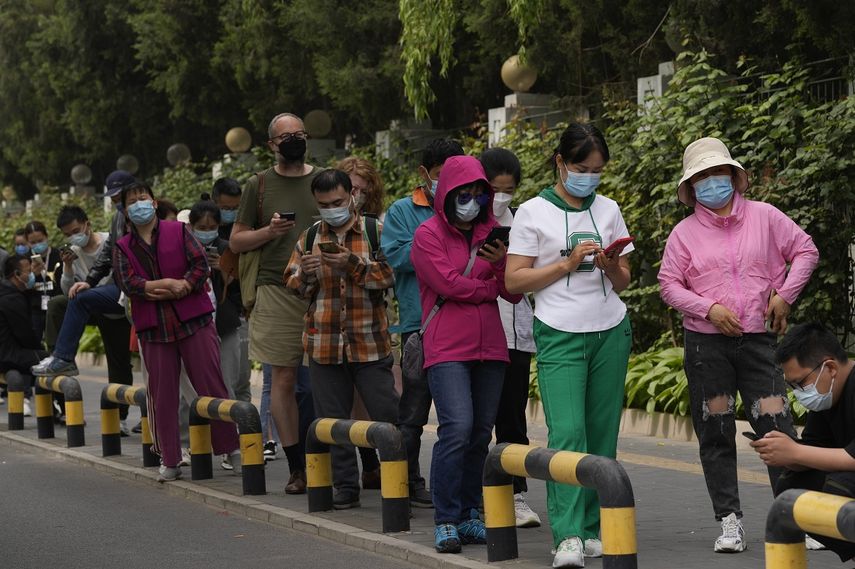 Vecinos con mascarillas hacen fila para hacerse pruebas de COVID-19 en el distrito de Chaoyang, el lunes 25 de abril de 2022 en Beijing.&nbsp;