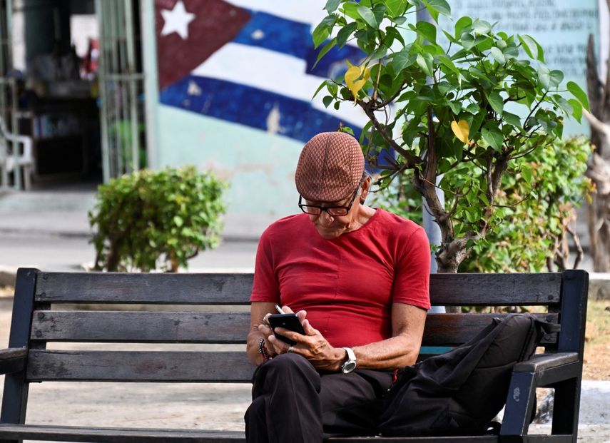 Un hombre usa su teléfono móvil en una calle de La Habana el 3 de junio de 2025. Las nuevas tarifas de internet móvil en Cuba, que entraron en vigor el 30 de mayo y dolarizaron parcialmente el servicio, han desatado una ola de descontento entre los usuarios.&nbsp;