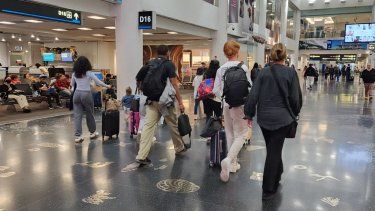 Viajeros en uno de los pasillos centrales del Aeropuerto Internacional de Miami.