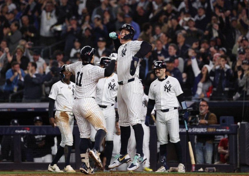 &nbsp;Aaron Judge #99, Giancarlo Stanton #27, Jazz Chisholm Jr. #13 y Austin Wells #28 de los Yankees de Nueva York felicitan a Anthony Volpe #11 en el plato después de que Volpe conectara un jonrón con las bases llenas durante la tercera entrada del cuarto juego de la Serie Mundial 2024 contra los Dodgers de Los Ángeles en el Yankee Stadium el 29 de octubre de 2024