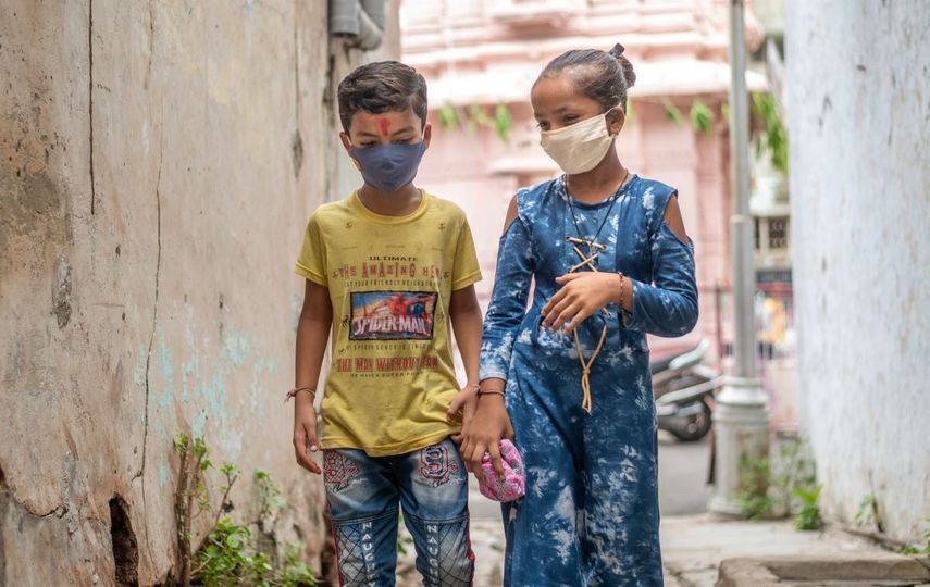 Dos niños con mascarilla en India.