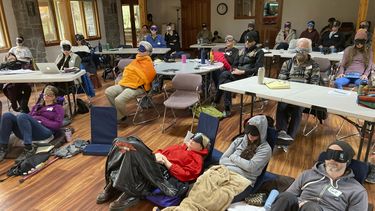 Personas que estudian para ser facilitadores de psilocibina están sentados con mascarillas mientras escuchan música durante un actividad experiencial en una sesión de capacitación de InnerTrek, cerca de Damascus, Oregon, el 2 de diciembre de 2022.