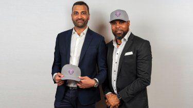 En esta foto suministrada por Baseball United, el exgrandeliga Barry Larkin (derecha), codueño de Baseball United, y Kash Shaik, CEO y codueño, posan con los gorros de Mumbai Cobras en la presentación de la franquicia en Cincinnati, Ohio, el viernes 5 de mayo de 2023.