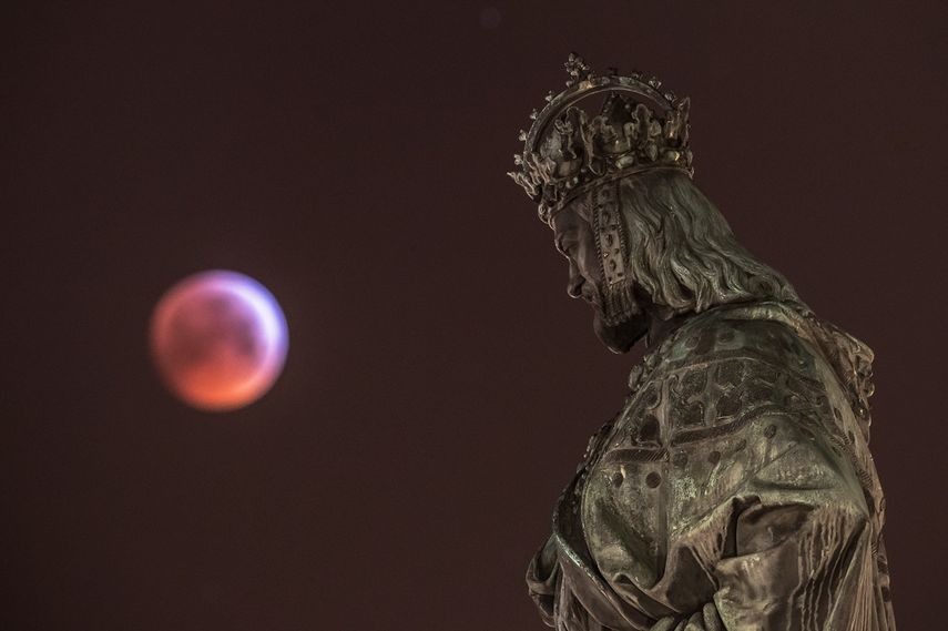 Súper luna de sangre vista desde Praga, República Checa, junto a la estatua de Carlos IV este lunes. 