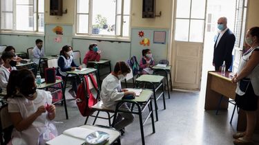 Foto del folleto publicado por el Gobierno de la Ciudad de Buenos Aires que muestra al alcalde Horacio Rodríguez Larreta (2-R) mirando a los escolares mientras toman clases en una escuela pública en su primer día de clases en Buenos Aires el 17 de febrero de 2021, en medio de la pandemia de COVID-19. Los escolares de cinco de los 24 distritos argentinos regresaron a las aulas el miércoles, en una lenta reapertura del ciclo educativo presencial.