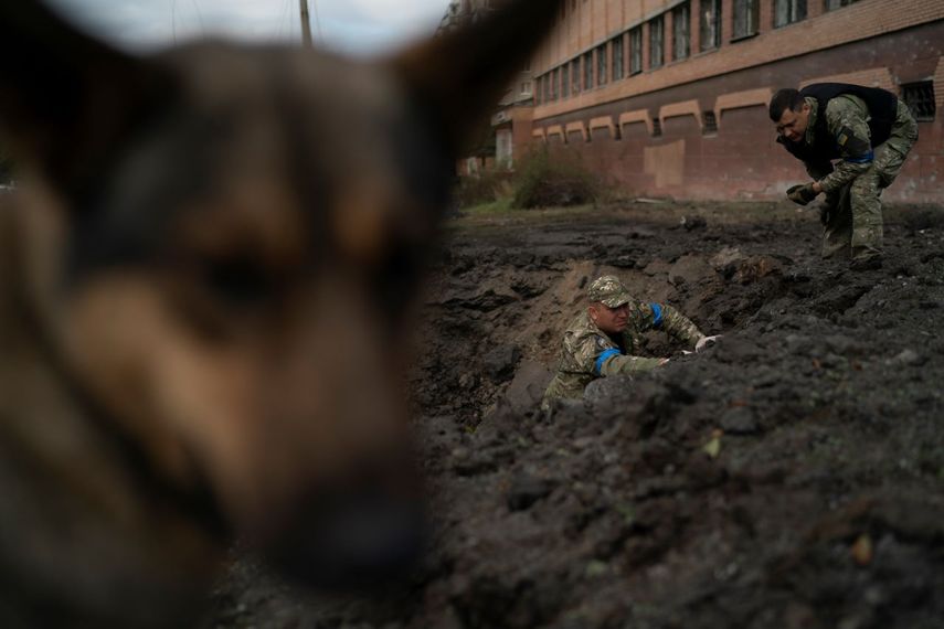 Policías ucranianos recolectan fragmentos de un cráter para determinar el tipo de munición de un ataque ruso, el jueves 29 de septiembre de 2022, en Kramatorsk, Ucrania.&nbsp;