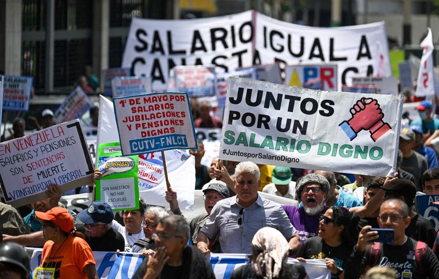 Cientos de venezolanos marchan durante una protesta por el Día del Trabajo en Caracas el 1 de mayo de 2025. Un grupo de empleados públicos y jubilados protestaron en Caracas el jueves para exigir un salario digno, horas después de que Nicolás Maduro anunciara un aumento en las pensiones y bonificaciones de los empleados públicos.