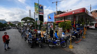 Los transe&uacute;ntes esperan en la cola para repostar los tanques de su motocicleta con gasolina en una estaci&oacute;n de servicio, en Caracas, el 7 de abril de 2020 en medio del nuevo brote de coronavirus (COVID-19). La econom&iacute;a de Venezuela atraviesa una crisis sin precedentes.