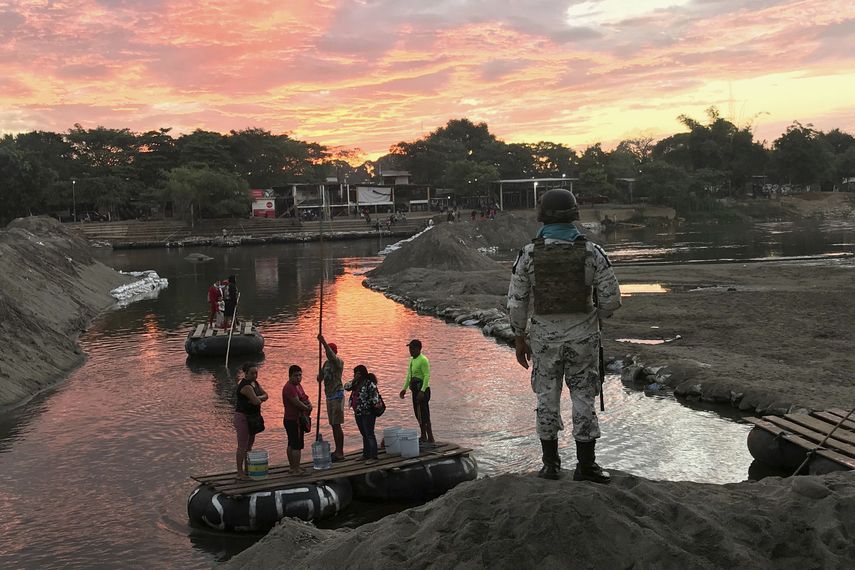 Un miembro de la Guarda Nacional de M&eacute;xico mira mientras residentes cruzan el r&iacute;o Suchiate, cerca de Ciudad Hidalgo, en la frontera con Guatemala, el 17 de enero de 2020.&nbsp;
