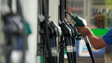 Un conductor toma una boquilla para cargar gasolina a su automóvil.