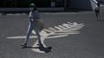 Una mujer con una m&aacute;scara para protegerse del coronavirus camina sobre un dibujo de la Palma de Oro frente al Palais des Festivals en Cannes, Francia, el martes 12 de mayo de 2020.&nbsp;