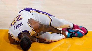 El alero de los Lakers de Los Ángeles LeBron James se toca el tobillo tras sufrir una lesión en el encuentro ante los Hawks de Atlanta el sábado 20 de marzo del 2021