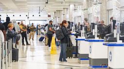 Un agente de ICE dirige a los pasajeros mientras otros agentes de ICE y miembros de la TSA revisan las identificaciones en el mostrador de seguridad de la TSA en el Aeropuerto Internacional Hartsfield-Jackson de Atlanta el 28 de marzo de 2026 en Atlanta, Georgia.