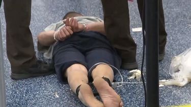 Emilio Nivaldo López (en el suelo) fue atado de pies y manos tras protagonizar una agresión a un agente federal en el Aeropuerto Internacional de Miami.