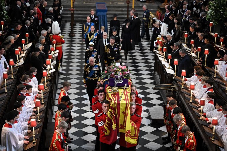 El ataúd de la Reina Isabel II, envuelto en el Estandarte Real con la Corona del Estado Imperial y el cetro del Soberano, se saca de la Abadía de Westminster, durante el Funeral de Estado de la Reina Isabel II, celebrado en Londres el 19 de septiembre de 2022.  