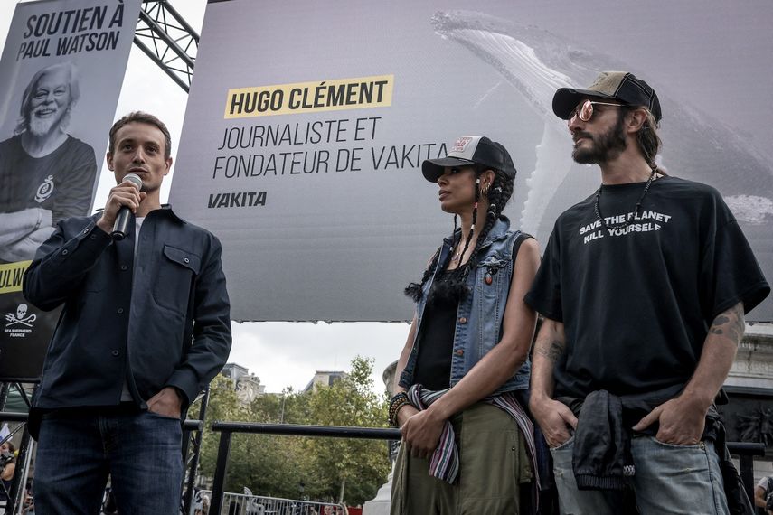 El periodista francés Hugo Clement (izq.) pronuncia un discurso junto a Samaha Sam (centro) y Frah, miembros de la banda de rock francesa Shaka Ponk, durante una manifestación en apoyo de la ONG Sea Shepherd, el fundador canadiense Paul Watson, en París el 4 de septiembre de 2024.&nbsp;