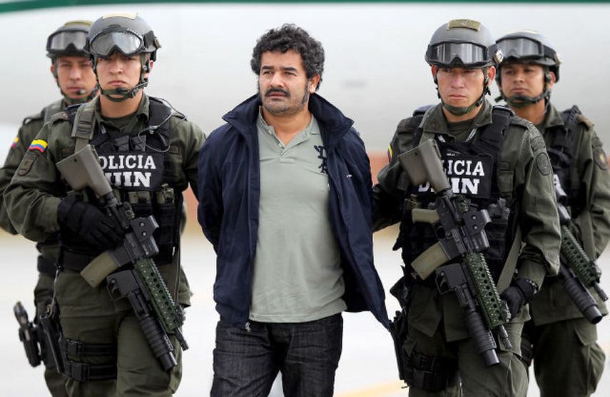 Miembros de la Policía de Colombia, custodian a Diego Pérez Henao (centro), alias Diego Rastrojo, considerado el jefe de la banda de origen paramilitar Los Rastrojos, a su llegada el 25 de julio de 2012, a Bogotá (Colombia). EFE/LEONARDO MUÑOZ