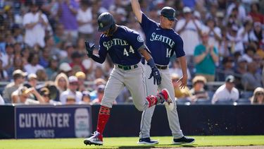 Julio Rodríguez, izquierda, de los Marineros de Seattle, reacciona con el coach de tercera base Manny Acta después de pegar jonrón de dos carreras durante la cuarta entrada del juego de béisbol en contra de los Padres de San Diego, el lunes 4 de julio de 2022.