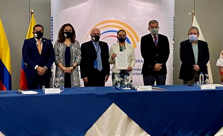 El expresidente Andrés Pastrana, luego de su lectura, entrega a Diana Atamaint, presidenta del Consejo Nacional Electoral de Ecuador la declaración de IDEA sobre el proceso electoral celebrado en Ecuador.