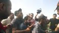 Palestinos transportan a un civil israelí capturado en el Kibbutz Kfar Azza, Israel, a la Franja de Gaza, sábado 7 de octubre de 2023.&nbsp;