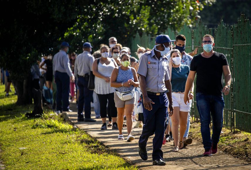 Gente con mascarillas en medio de la pandemia del nuevo coronavirus se forma para entrar a una tienda de alimentos que acepta d&oacute;lares estadounidenses en La Habana, Cuba, el lunes 20 de junio de 2020.