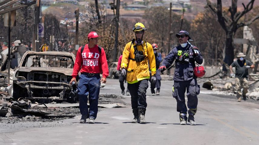 Miembros del equipo de búsqueda y rescate caminan por una calle el sábado 12 de agosto de 2023 en Lahaina, Hawai, tras un incendio que provocó graves daños.&nbsp;