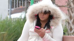 Una joven se resguarda del frío en Miami. Una joven se resguarda del frío en Miami.