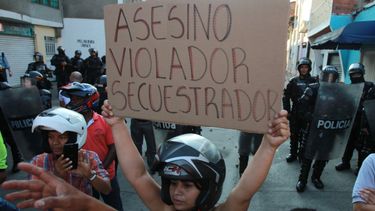 Una mujer muestra una pancarta en el lugar donde el candidato a la presidencia por el partido de las FARC, Rodrigo Londoño, pretendía asistir a un acto de campaña.