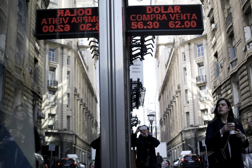 Una mujer camina bajo un cartel que muestra los tipos de cambio entre el dólar estadounidense y el peso argentino en Buenos Aires, Argentina, el lunes 2 de septiembre de 2019.&nbsp;