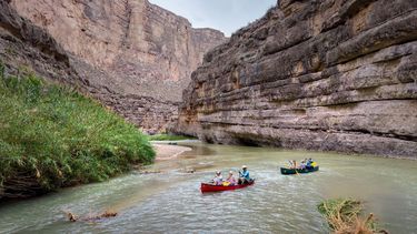 Desde una vista aérea se observa a familias remando por el río Grande a través del Cañón Santa Elena hacia un campamento en el Parque Nacional Big Bend, Texas.