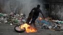 Un manifestante patea un neumático en llamas durante una protesta en Puerto Príncipe, Haití, el lunes 22 de agosto de 2022.