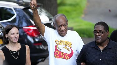 El comediante Bill Cosby, centro, y el vocero Andrew Wyatt, derecha, se acercan a miembros de los medios reunidos fuera de la casa de Cosby en Elkins Park, Pensilvania.&nbsp;
