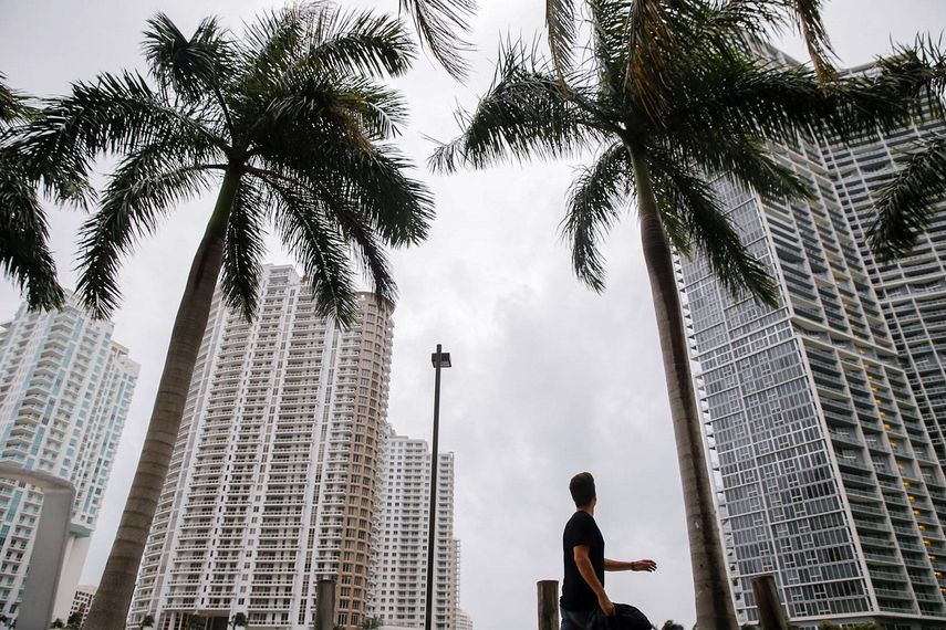 Un hombre camina entre los edificios altos de Miami.