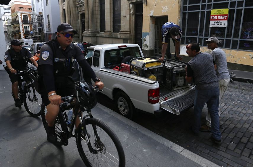 Dos agentes de Policía recorren en bicicleta las calles de San Juan, en Puerto Rico, días antes del paso del huracán María.
