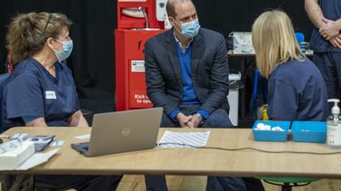 El príncipe William de Inglaterra, en el centro, conversa con personal y voluntarios durante su visita a un centro de vacunación contra el coronavirus en Kings Lynn, el lunes 22 de febrero de 2021.