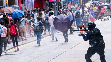 China, Hong Kong: un agente de la policía antidisturbios dispara proyectiles de gas pimienta a los manifestantes durante una manifestación contra la segunda lectura del Proyecto de Ley del Himno Nacional