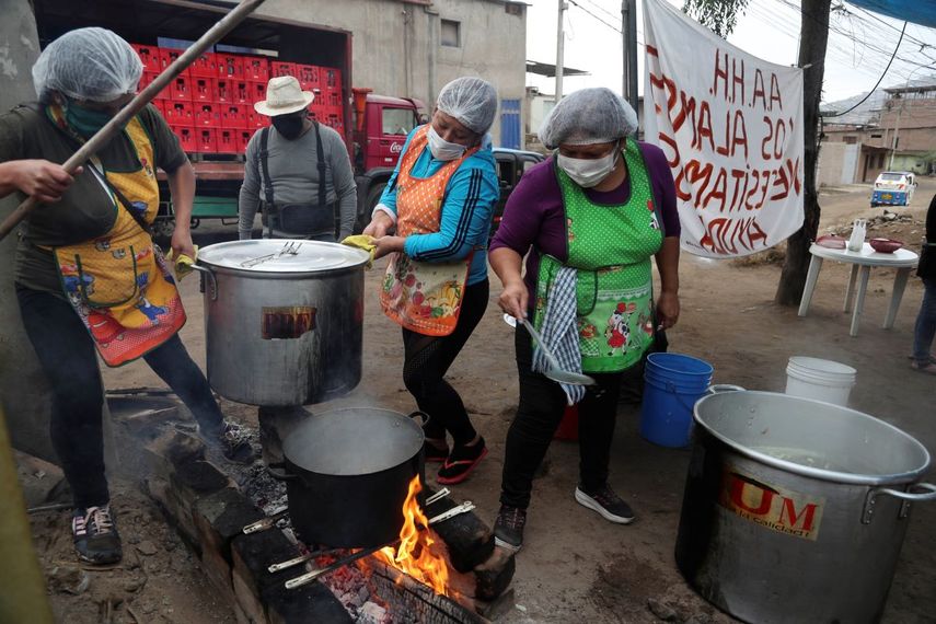 Mujeres preparan comida para un grupo de familias que enfrentan dificultades por la pandemia del nuevo coronavirus en Villa Mar&iacute;a del Triunfo en Lima, Per&uacute;.&nbsp;