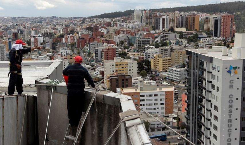 Unos trabajadores limpiando un edificio en Quito. (REUTERS)