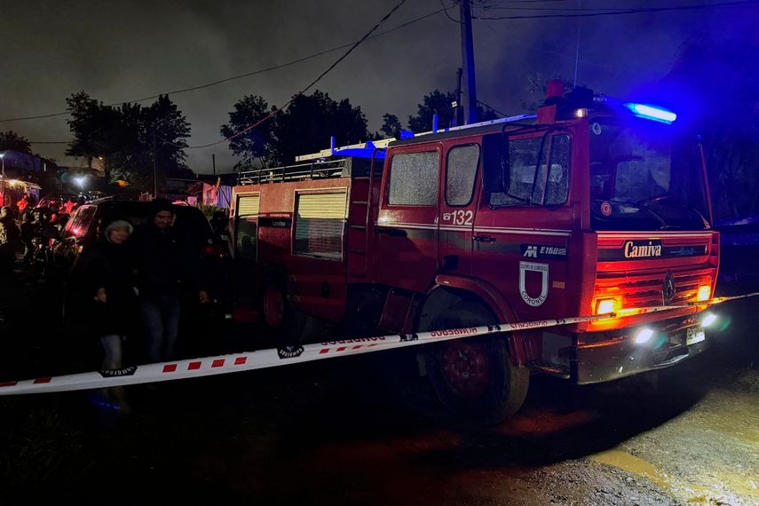 Vista de un camión de bomberos estacionado cerca del lugar donde un incendio arrasó un asentamiento habitacional matando a 14 migrantes venezolanos, entre ellos ocho niños, en el campamento Los Pirquenes, en el sector Cerro Obligado de la comuna de Coronel, Región del Bío Bío, Chile